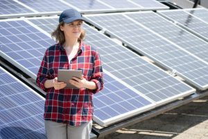 Woman with clipboard standing next to solar array